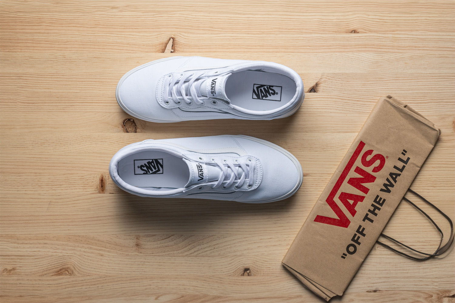 un par de zapatos blancos en una superficie de madera