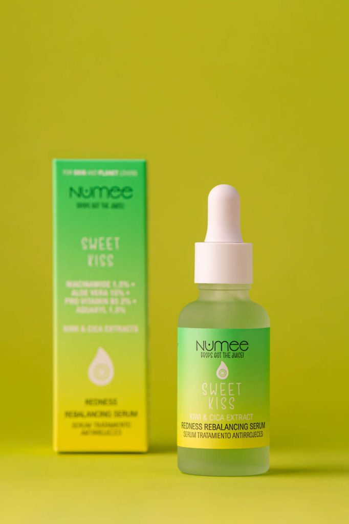 una caja desenfocada de serum y el bote enfocado al lado juntos en un fondo verde