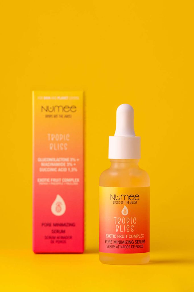 una caja desenfocada de serum y el bote enfocado al lado juntos en un fondo amarillo