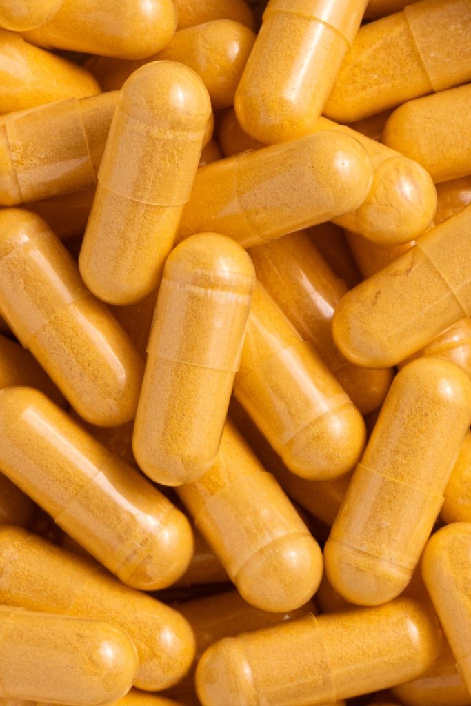 Fotografía macro de cápsulas doradas de complemento alimenticio en detalle extremo, realizada por fotógrafo de complementos alimenticios en Sevilla