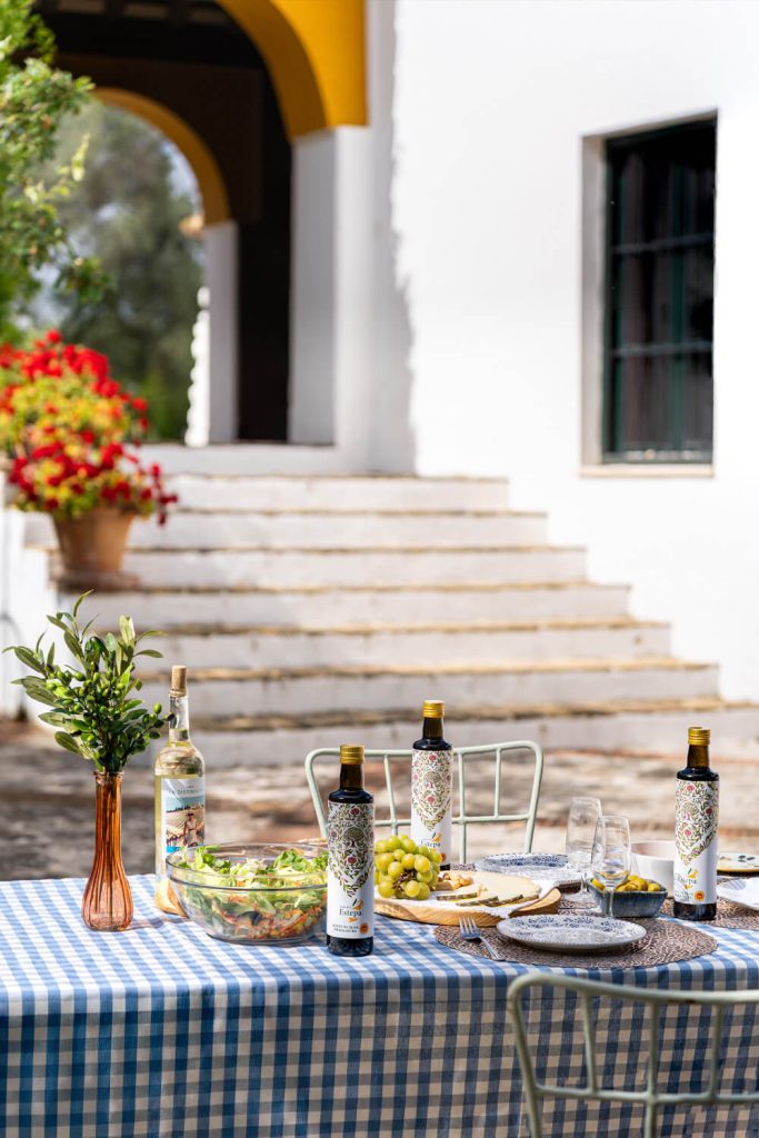 Fotografía de botellas de aceite de oliva Estepa en mesa de cortijo andaluz al aire libre