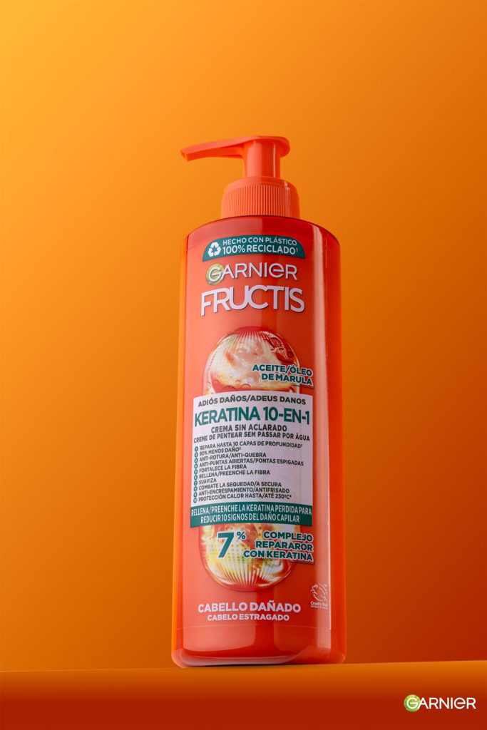 Fotografía de producto cosmético Garnier Fructis Keratina sobre fondo naranja en estudio Sevilla